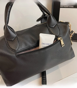 Detail view of the back zipper pocket on the black pebble leather Boston shoulder bag