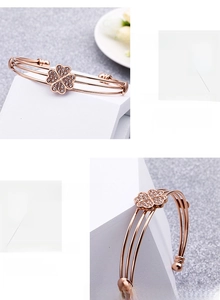 Dettaglio del bracciale triplo strato in oro rosa con quadrifoglio in zirconi