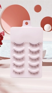 Detailed view of 5 pairs of natural fake eyelashes on a pink tray for daily makeup