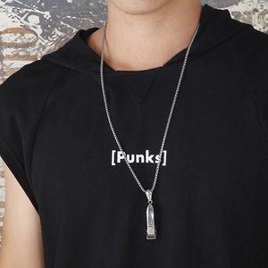 Gros plan d'un collier pendentif coupe-ongles argenté porté par un mannequin style urbain