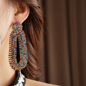 Detailed close-up of vintage oval drop earrings with colorful zircon rhinestones on model