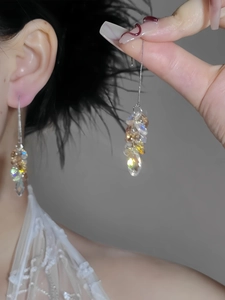 Detailed view of silver needle tassel earrings with multi-faceted Aurora crystal beads