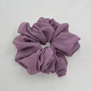 Close-up of a soft purple chiffon scrunchie showing elastic texture and fabric folds