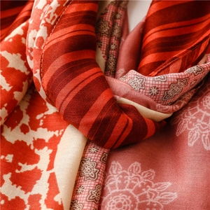 Close-up of red cotton linen scarf featuring detailed paisley and floral patterns