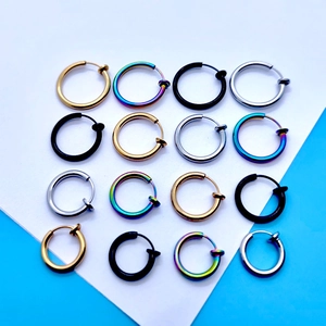 Top view of sixteen circular spring ear clips in gold, silver, black, and rainbow colors