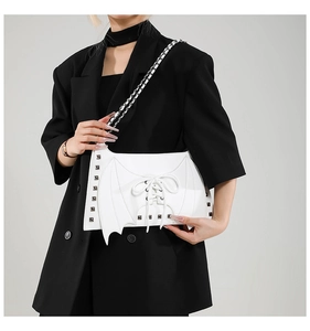 Détail de sac à bandoulière blanc aile de chauve-souris avec rivets de style gothique.