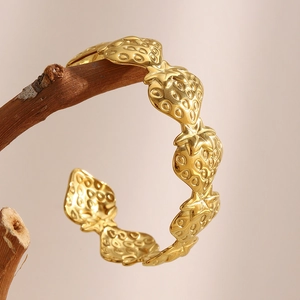 18K gold plated strawberry geometric open bracelet with textured seeds on warm background