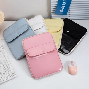 Flat lay of colorful laptop sleeves in pink, blue, yellow, and black on a minimalist desk