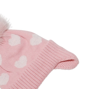Detailansicht der rosa Strickmütze mit weißen Herzmustern und einem flauschigen Pompon