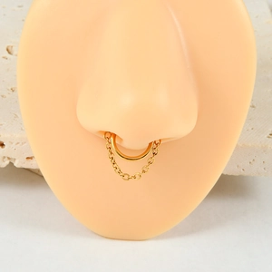 Detailed close-up of golden nose ring with vertical chain on a realistic model