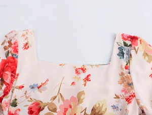 Detailed macro view of pink floral fabric showing square neckline and vibrant flower patterns