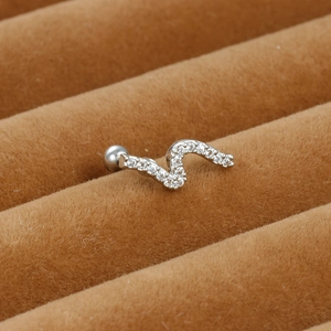 Close-up of S-shaped silver ear stud with micro-paved zircons on brown velvet display