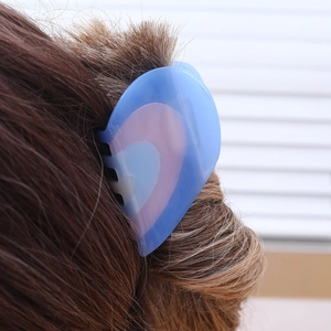 French style heart-shaped hair claw clip in blue and pink resin on brown hair