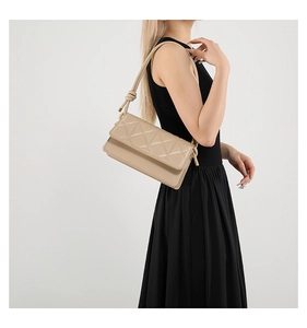 Close-up of geometric quilted shoulder bag with knotted strap details and gold hardware