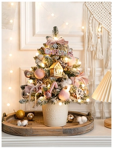Mini desktop Christmas tree with pink bows, LED lights, and rustic iron pot decoration