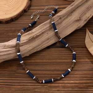 Surfer beaded necklace with blue white ceramic discs and coconut wood on rustic timber