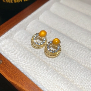 Macro view of gold hoop earrings with cat-eye stone and pavé cubic zirconia