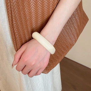 Chic cream acrylic geometric bangle shown on model for a minimalist fashion look