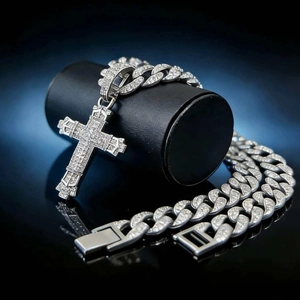 Silver iced out cross pendant necklace with Cuban chain on a professional dark background