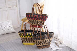 Detail of woven straw handbag featuring red, yellow, and brown striped fiber patterns