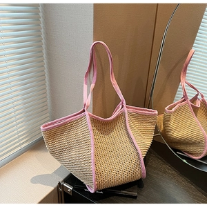 Close-up of beige woven tote bag with contrast pink trim and hollow-out texture