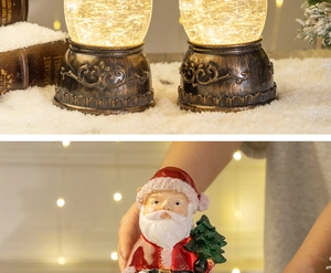 Detail of Santa Claus snow globe with vintage bronze base and warm LED lights