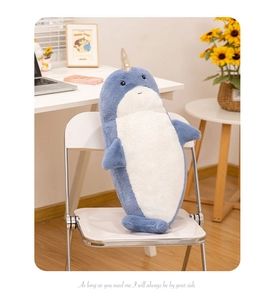 Blue plush narwhal with golden horn on chair with aesthetic home office background