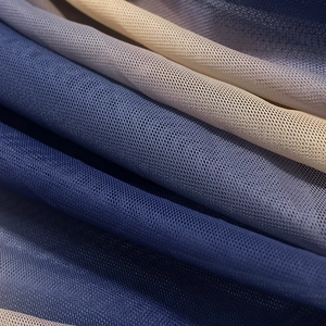 Close-up of pleated mesh fabric with navy and grey-blue gradient colors and texture
