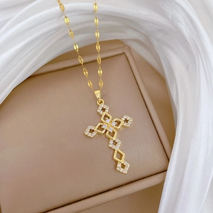 Titanium steel cross necklace with pavé zircons on a luxury beige jewelry box display