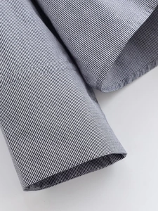 Detailed close-up of the black and white mini-check shirt cuff with fine stitching details