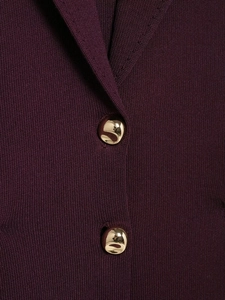 Détail de boutons métalliques dorés irréguliers sur un pull en maille violet foncé