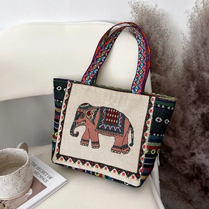 Close-up of ethnic embroidered elephant pattern and woven colorful straps on tote bag