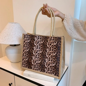 Detail of leopard print jute tote bag with woven handles shown in a lifestyle setting