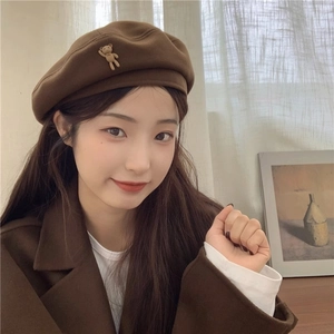 Detail of dark brown wool beret featuring a cute 3D teddy bear accent on the side