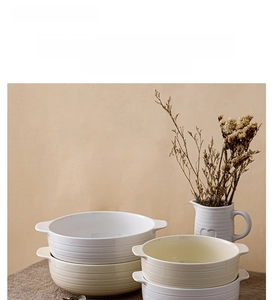 Macro shot of ceramic soup bowls with double handles and elegant embossed textures