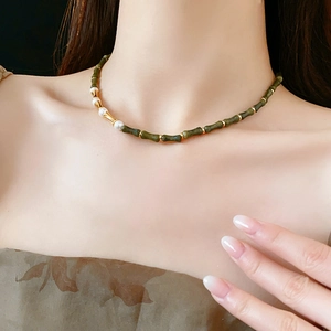 Dettaglio della collana vintage con perle di bambù verdi e perle bianche dorate