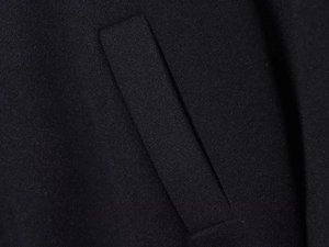Gros plan détaillé montrant les coutures professionnelles et la poche latérale du manteau noir