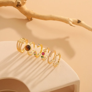 Macro detail of vintage gold rings set featuring tiger eye stone and colorful zircon stones