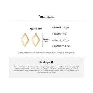 Detail view of geometric diamond gold earrings with copper material and silver needle specs