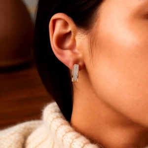 Gros plan sur les boucles d'oreilles en U plaquées or rose 18k avec zircons sur un mannequin