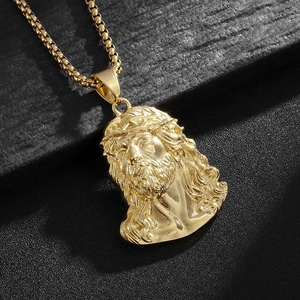 Macro shot of 18k gold plated Jesus head pendant with detailed crown of thorns on box chain