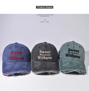 Detail showing distressed embroidery and worn edges on vintage washed canvas baseball caps