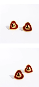 Detail view of heart-shaped earrings with red enamel and gold-plated metallic finish