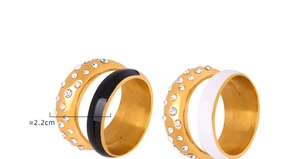 Détail de bagues en acier titane plaqué or 18 carats avec cristaux et émail noir et blanc