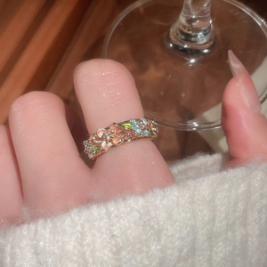 Close-up of gold plated enamel flower ring with zircon details worn by a model