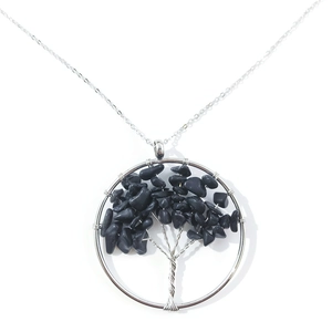 Detail of handmade Tree of Life necklace with silver wire and black natural stones