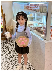 Detail of child wearing a brown plush paw cross-body bag with pink heart pads