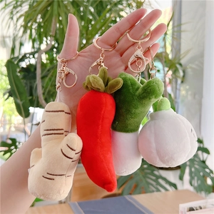 Plush vegetable keychains featuring ginger, chili, onion, and garlic held in hand