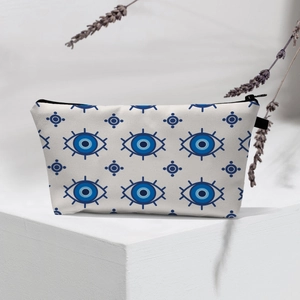 Detail showing Evil Eye pattern cosmetic bag with black zipper on geometric stand