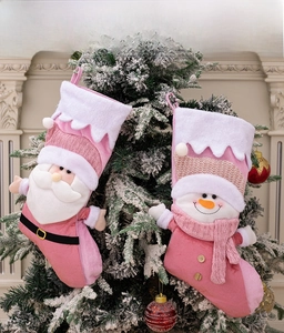 Detailed close-up of pink Nordic Christmas stockings with Santa and snowman on a tree